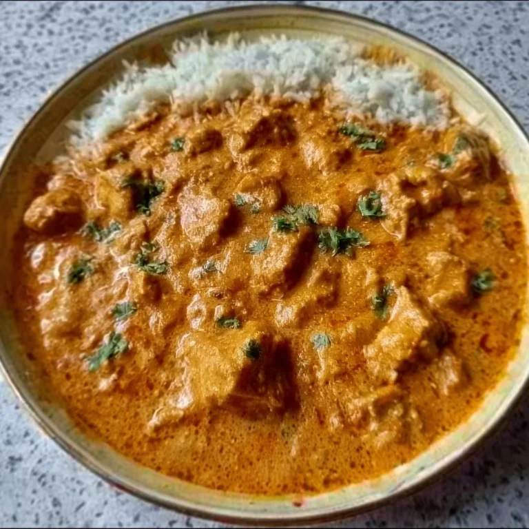 Delicious homemade butter chicken served with rice and garnish.